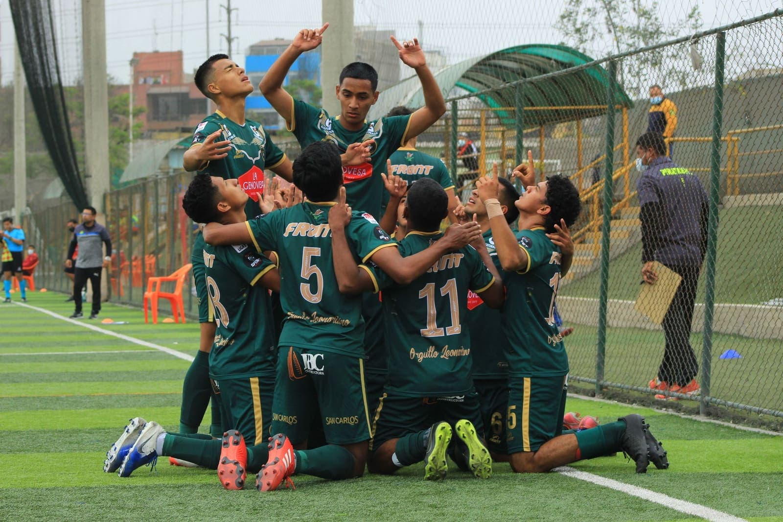 A youth football team celebrating a goal together