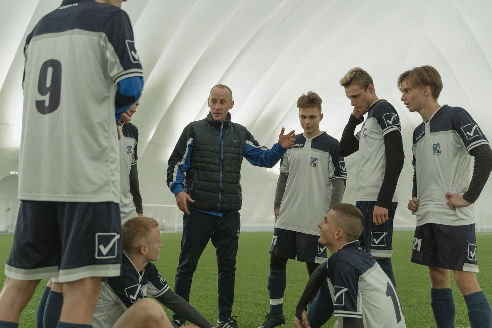 A coach giving instructions to a team of young players