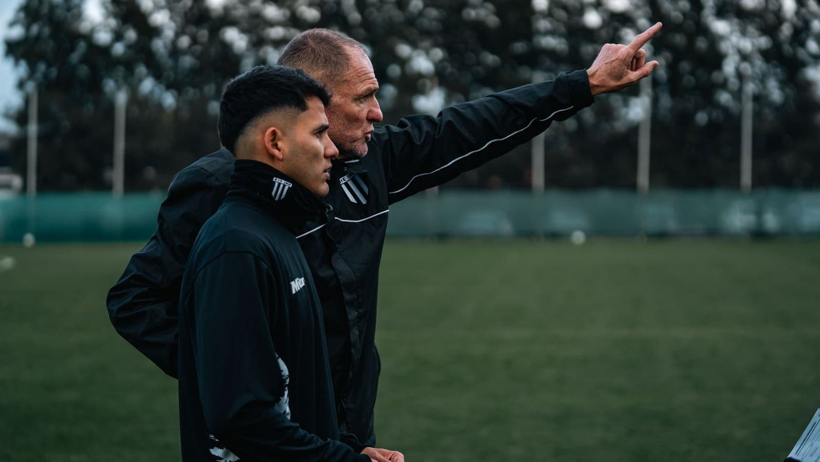 A coach talking with a young player during outdoor training