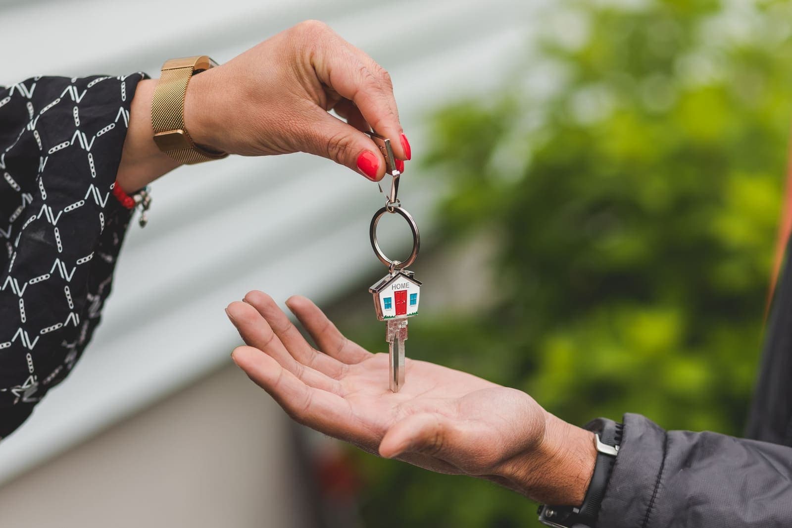 A hand passing a set of house keys to another