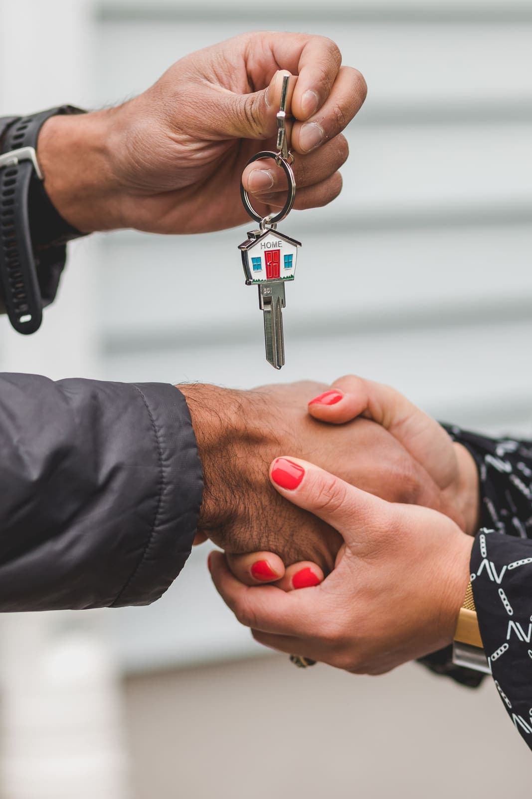 A handshake with a house key between two people